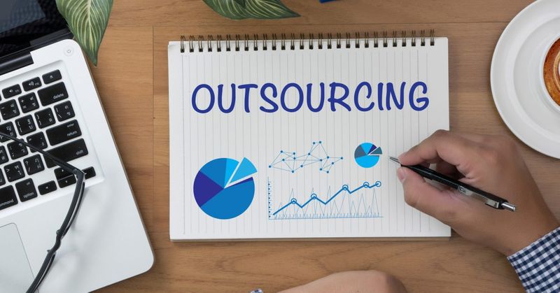 image of notepad with Outsourcing and charts on it